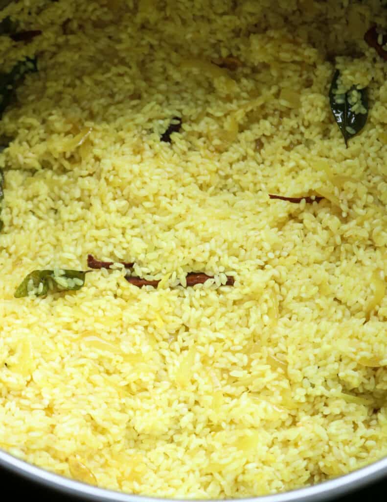 cooking the raw rice with the spices and turmeric powder.