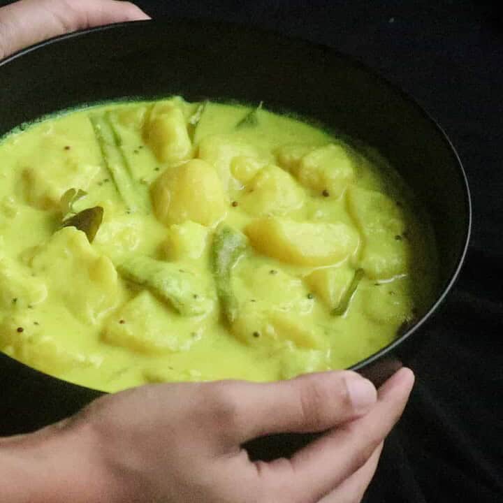 Tender potato cubes in a creamy coconut milk curry in a black bowl