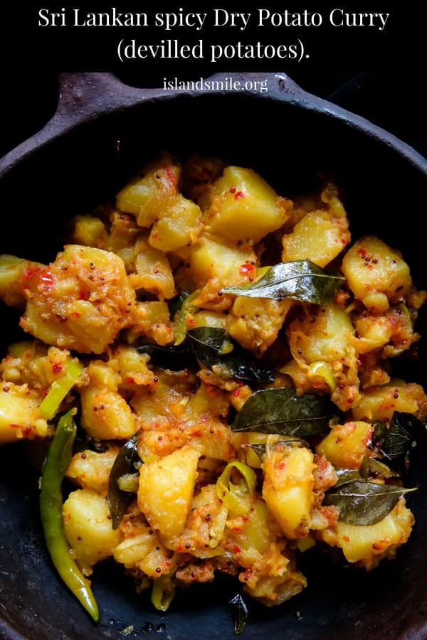 Sri Lankan spicy dry potato curry(deviled potatoes). with curry leavve and onions. placed in a clay pot