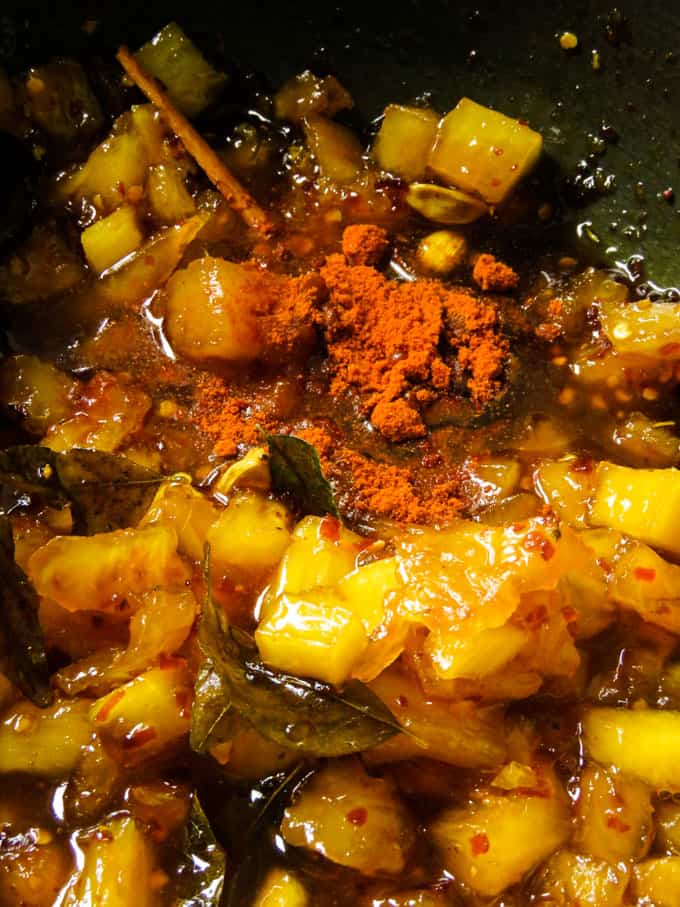 adding chilli powder to the pineapple relish.