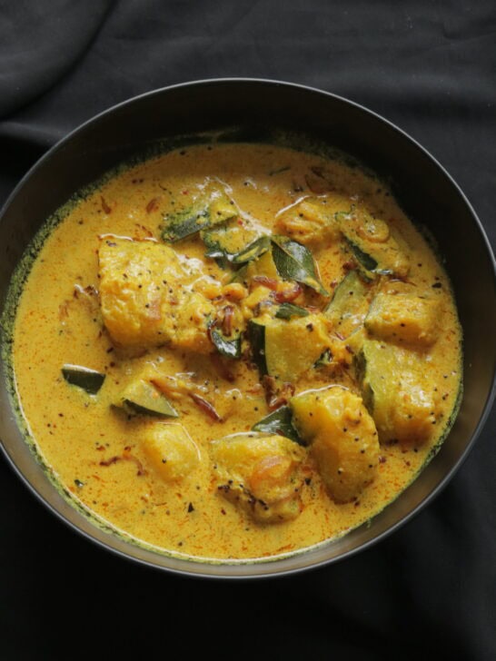creamy pumpkin curry served in a black bowl.