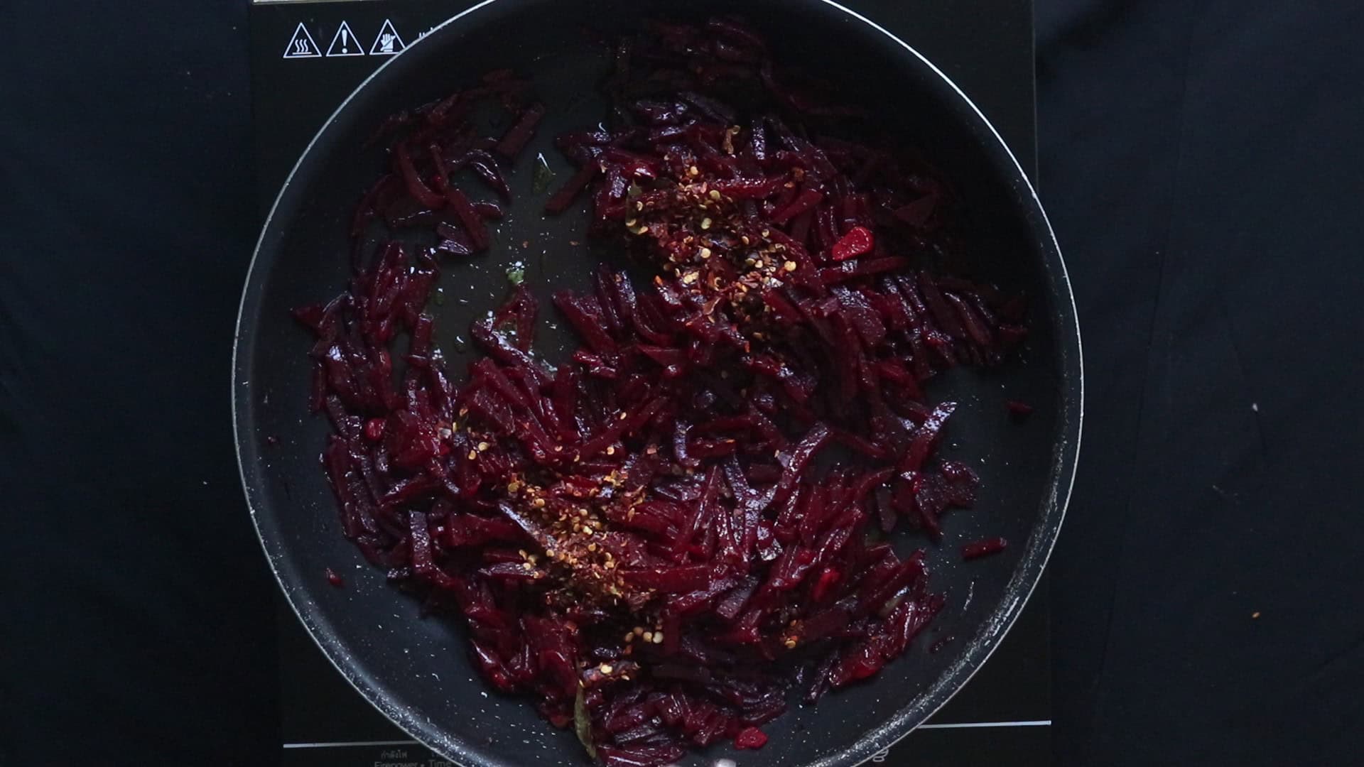 adding red chilli flakes and seasoning with salt to taste the beetroot curry.