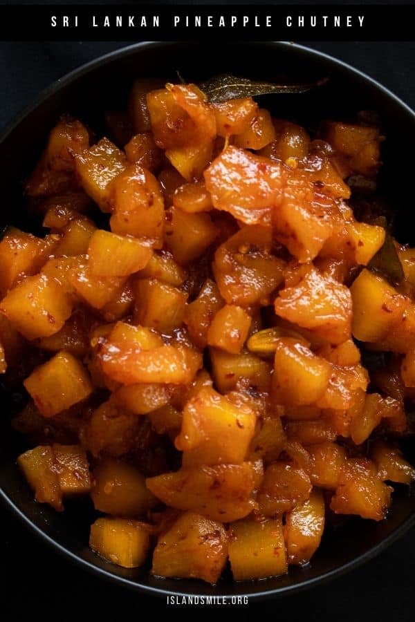 pineapple chutney with red chilli flakes served in a black bowl.