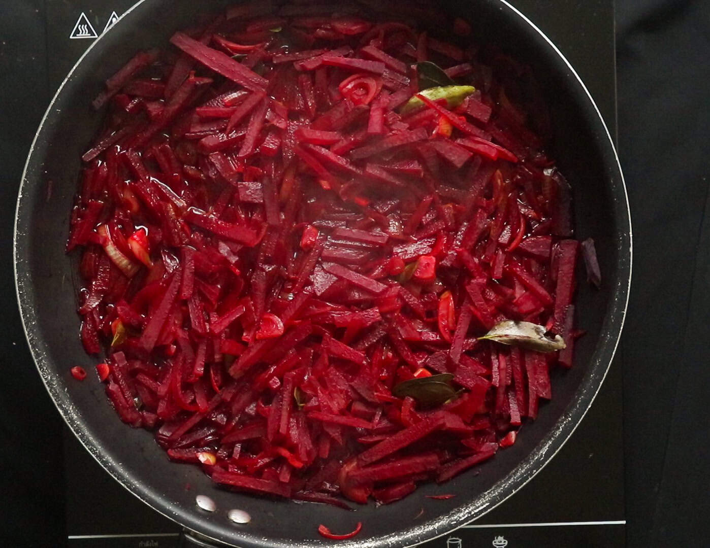 letting the water evaporate and cooking the beetroot strips until soft.