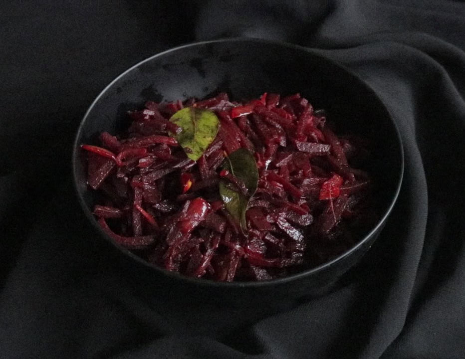 Sri lankan beetroot curry served in a black bowl.