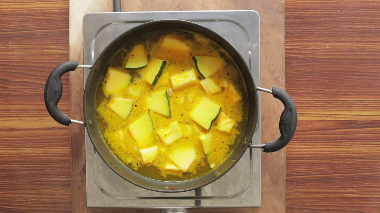 pumpkin cooking in a pan with spices and in water.