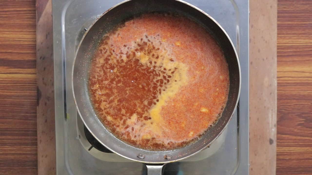 Cooking the pickling sauce over stove with vineagar, mustard powder, red chilli powder and sugar.