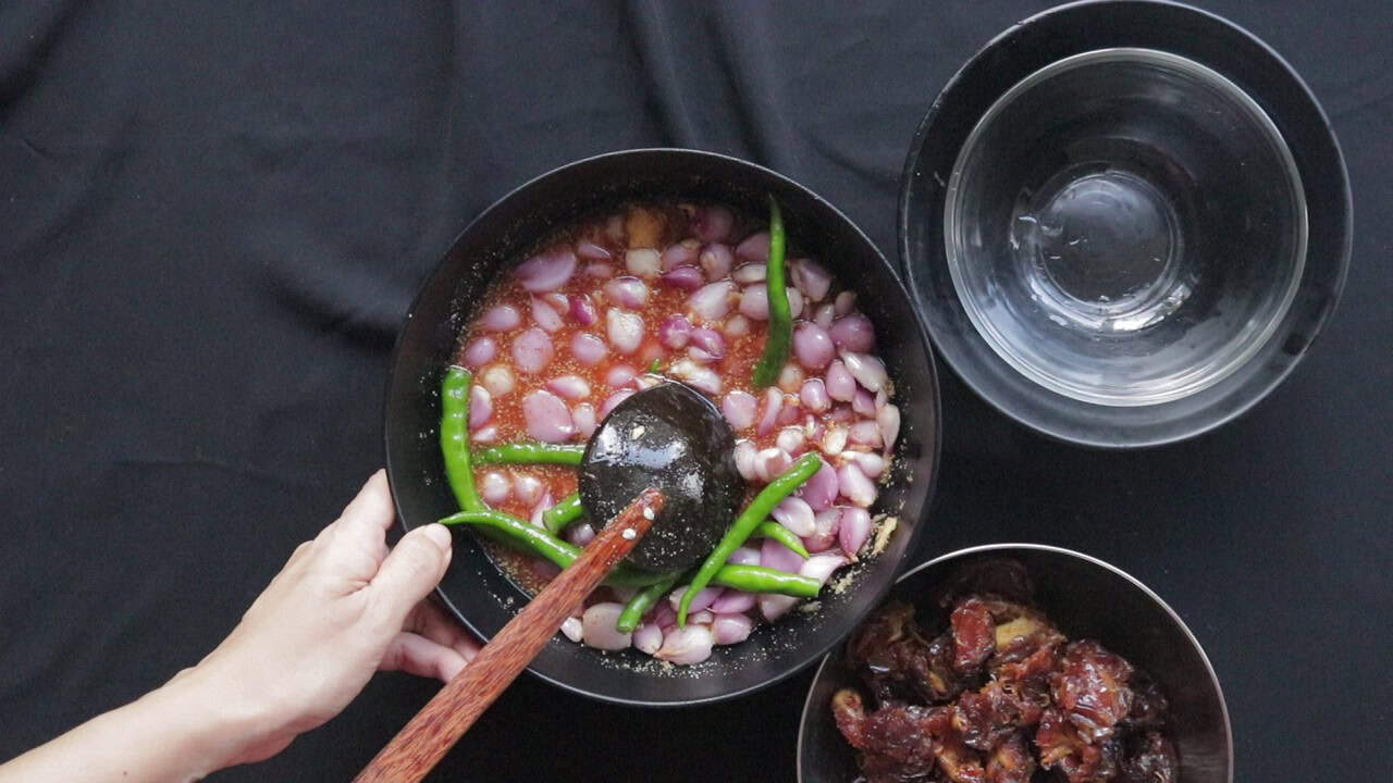 adding the shallots, green chillies and dates to the pickling sauce.