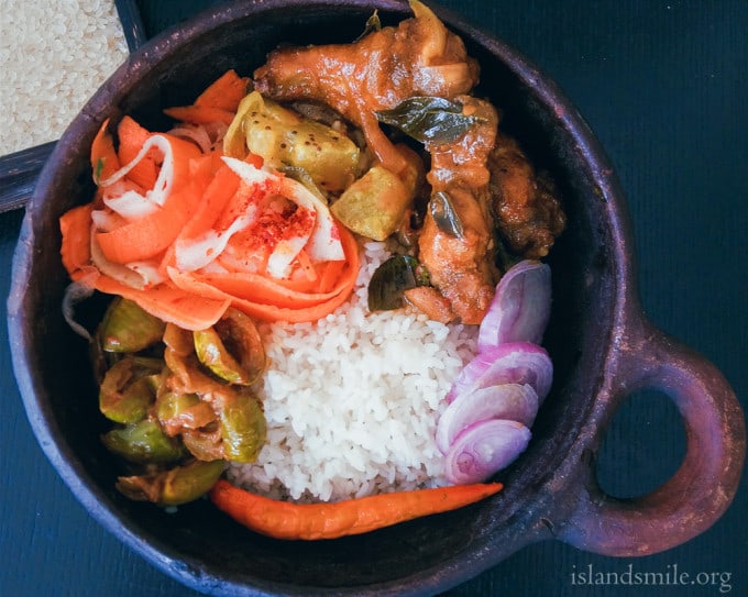 A meal in a bowl, Rice, Yellow Cucumber cooked in coconut milk, Dry Thai egg-plant curry, a salad of carrot ribbons, chicken drumsticks baked and cooked in a gravy with Srilankan spices.