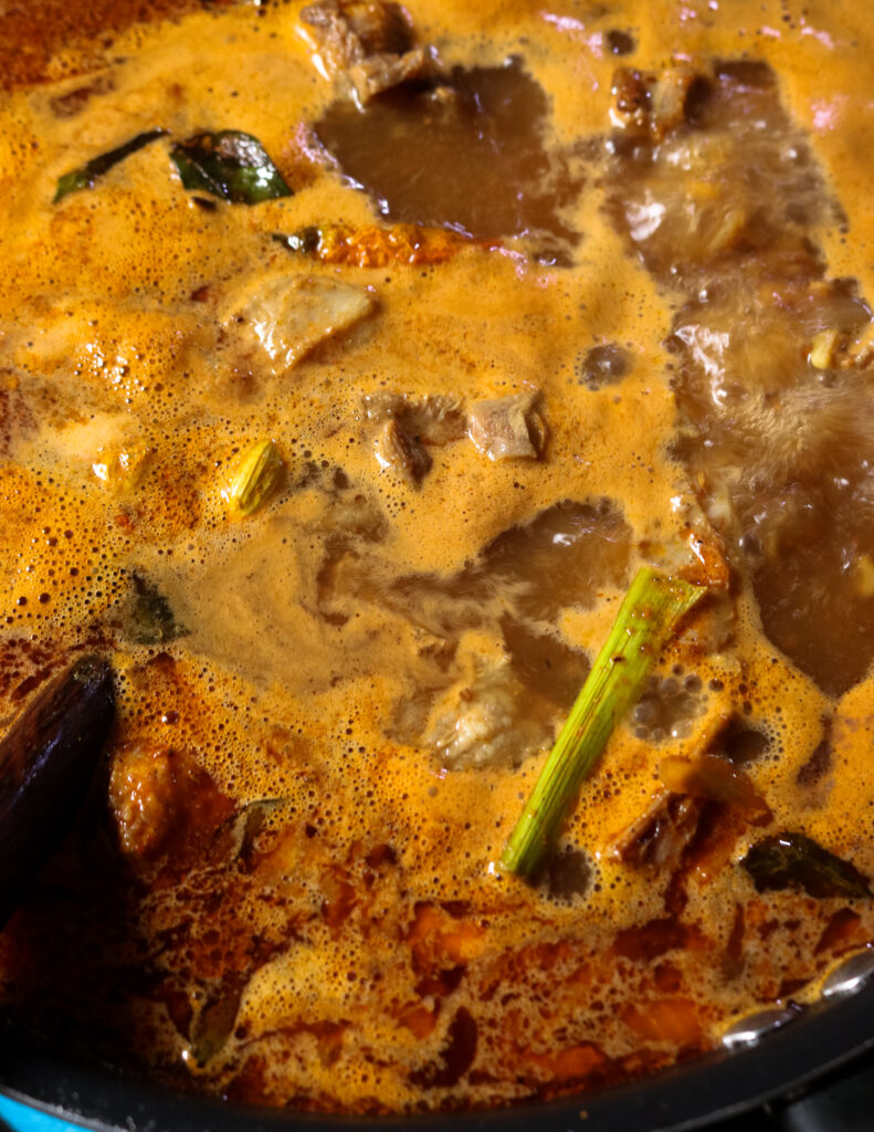 simmering gravy of mutton curry with pandan and mutton bones and meat