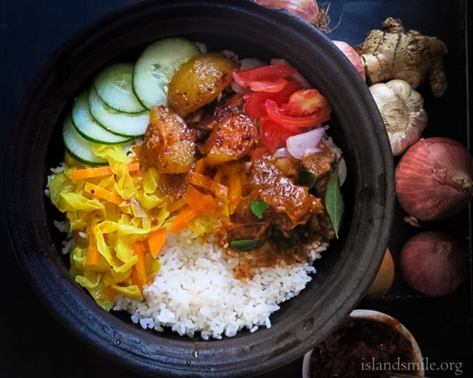 rice with cabbagge and carrots cooked in coconut milk,ambarella curry , spicy beef with a onion and tomato salad