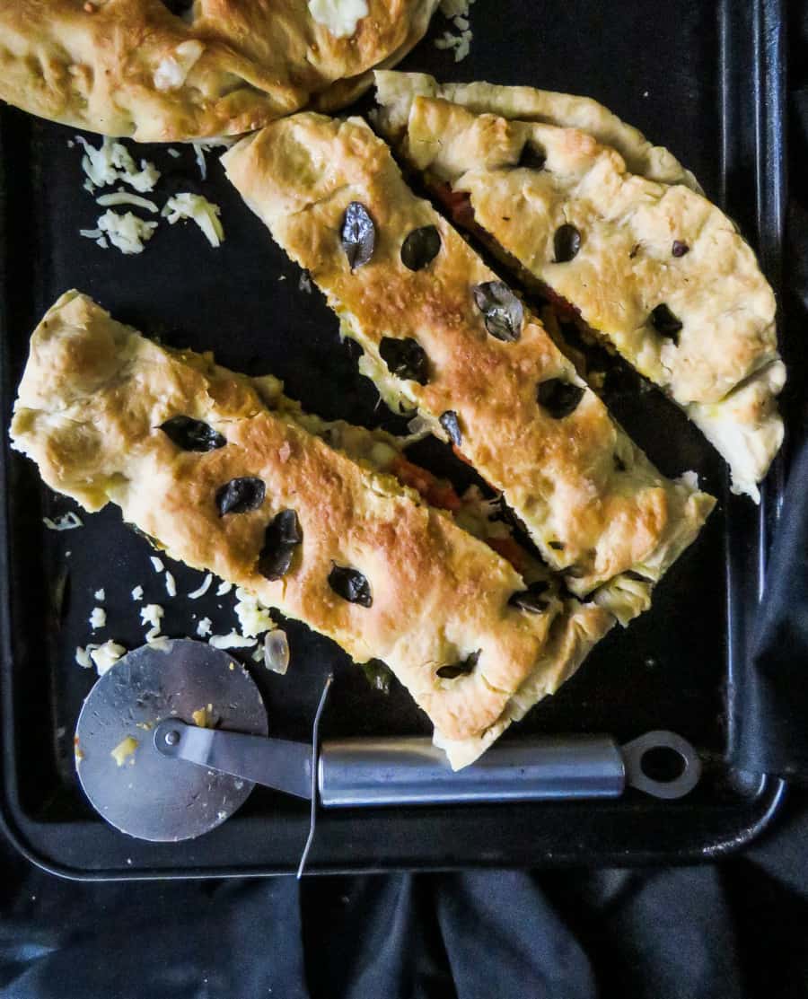 A dense flat bread with a slightly crusty surface with hurbs and salt sprinked on top, then stuffed with minced chicken and cheesy filling. It makes a great substitute for Pizza.