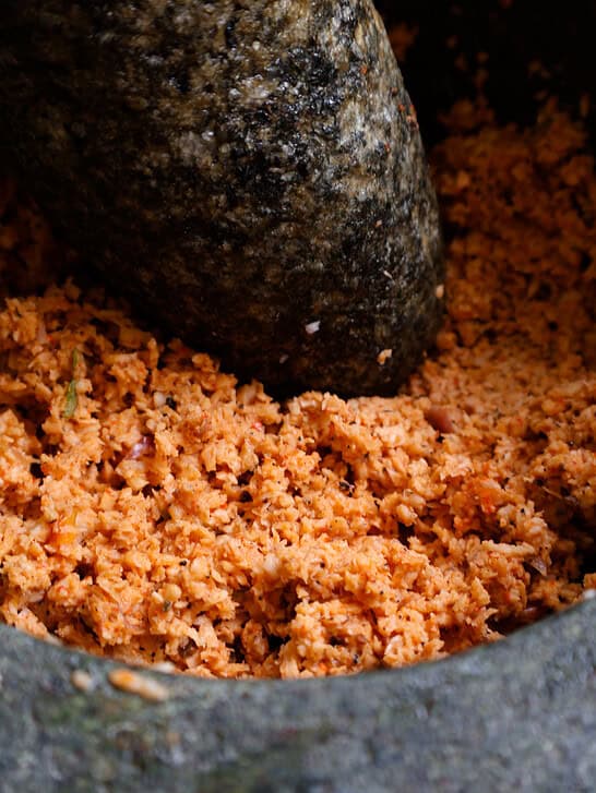 pol sambol or coconut sambol inside a mortar and pestle.