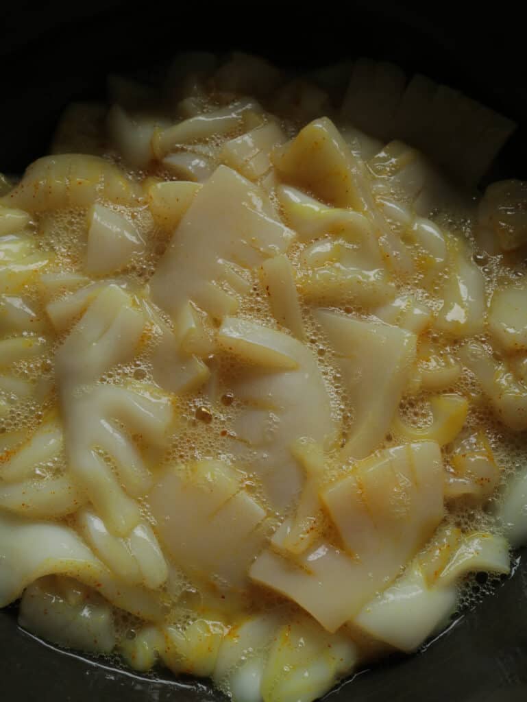 marinating the cuttlefish in egg whit in a black bowl.