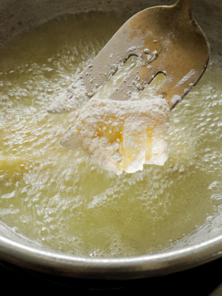 adding the battered cuttlefish into the oil