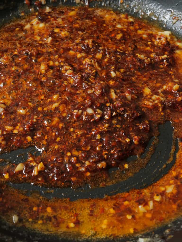 chilli paste cooked in butter and minced ginger and garlic in a frying pan.