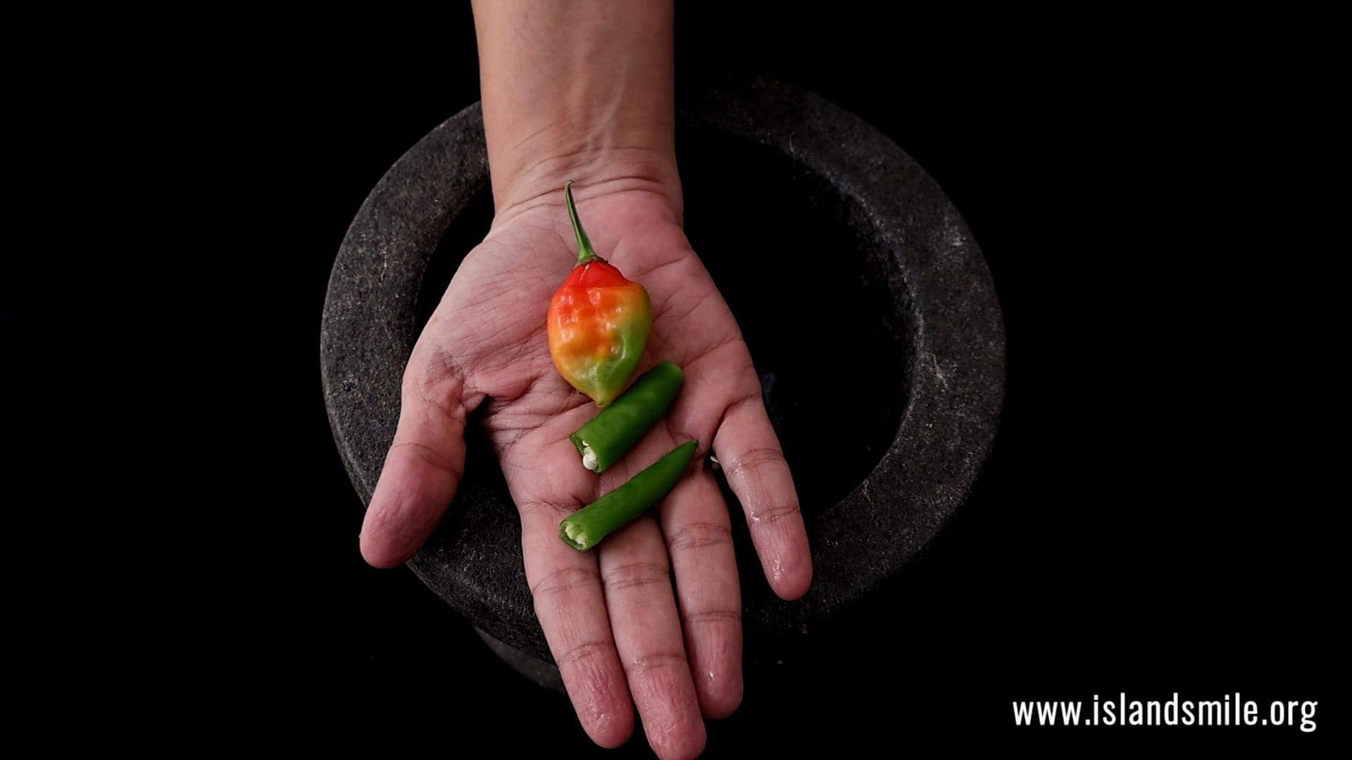 adding green chillies or scotch bonnet to make the pol sambol.