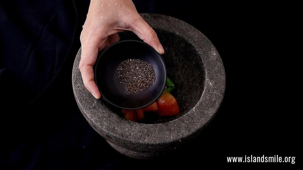 adding the black pepper powder to the coconut sambol.