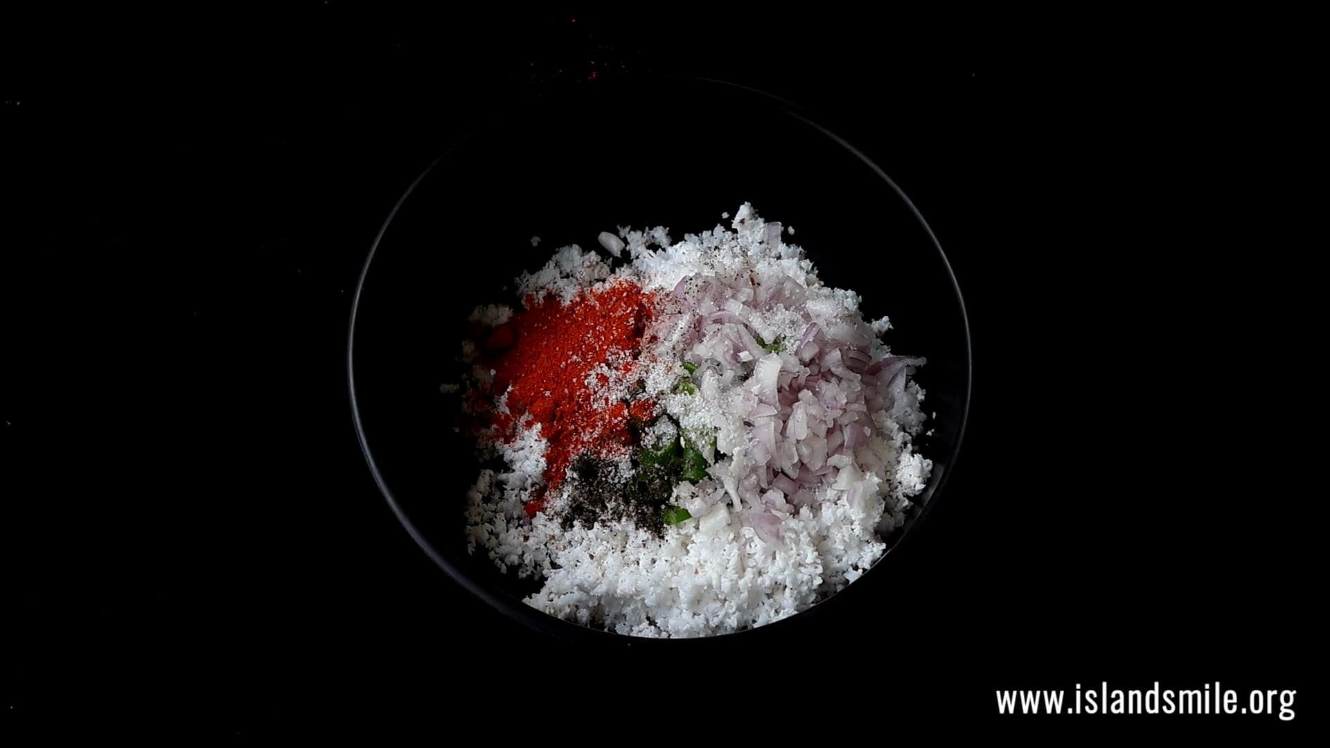 adding red chilli powder, black pepper powder to the coconut sambol.