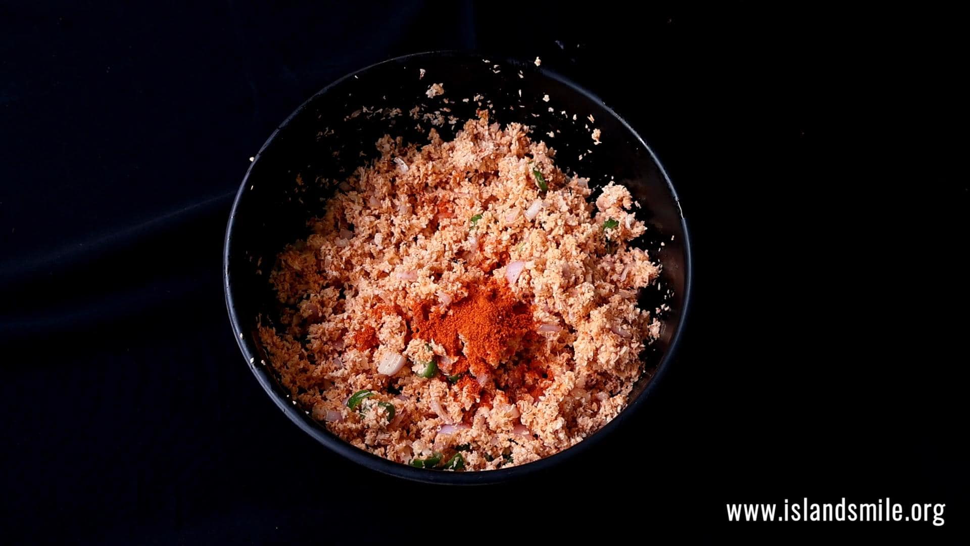 adding more red chilli powder and seasoning to make the pol sambol.