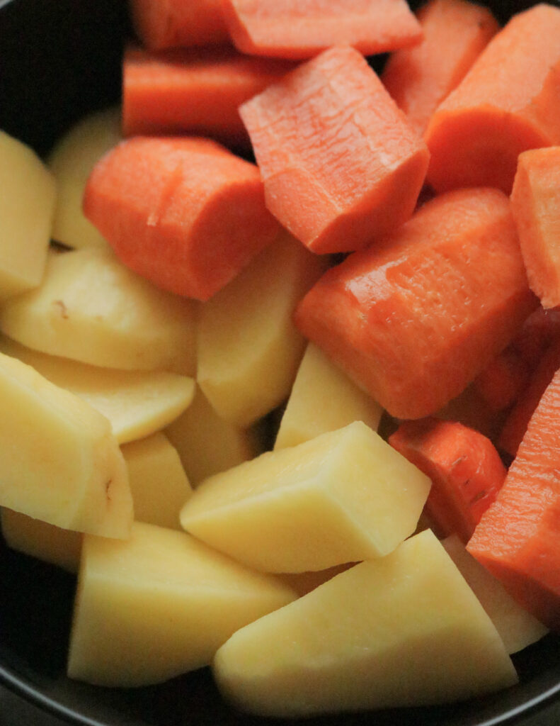 cutting the potatoes and carrots to large chunks to make the beef bone soup.