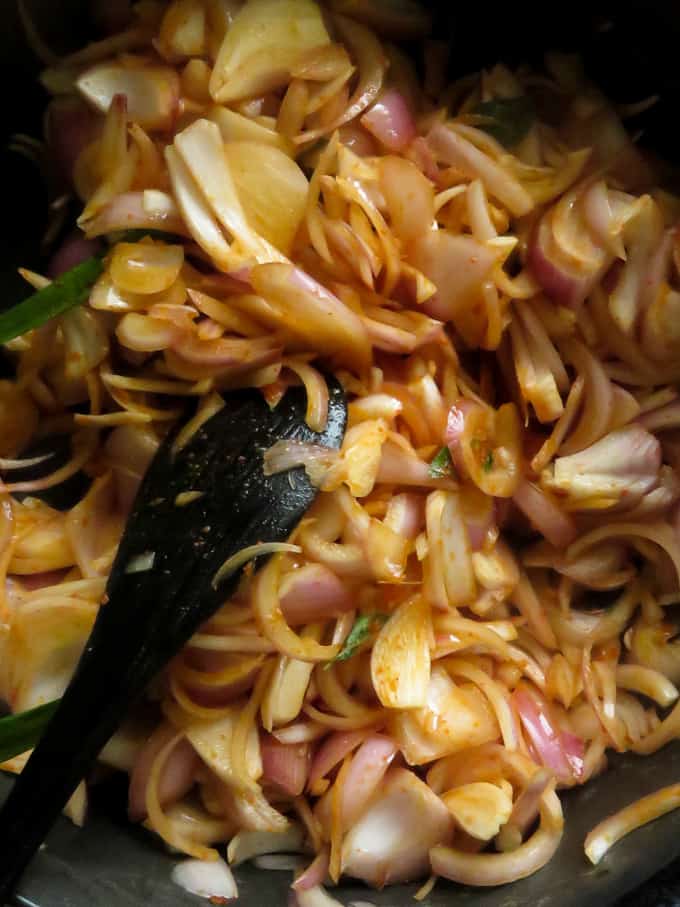 cooking down the raw onions to make the seeni sambol.