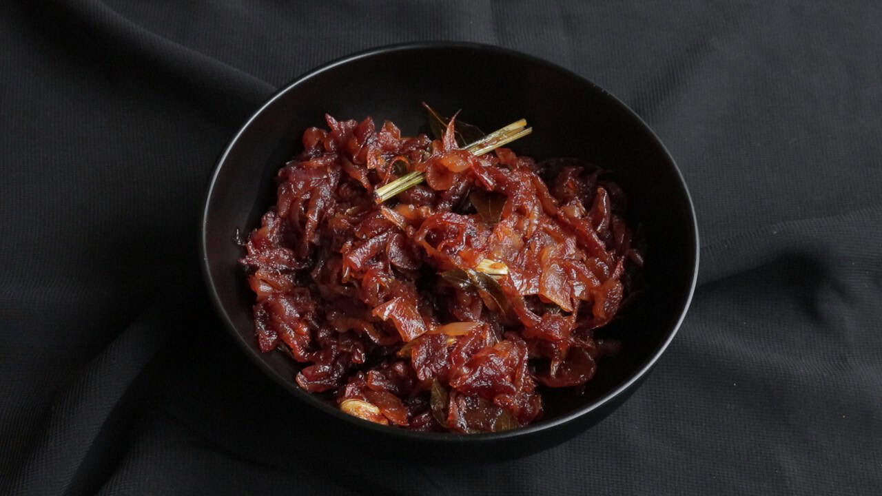 seeni sambol cooked down to make a sweet and spicy onion relish and served in a bowl.