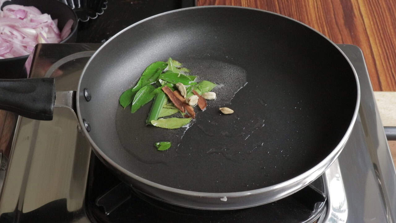 tempering the spices in oil to make seeni sambol.