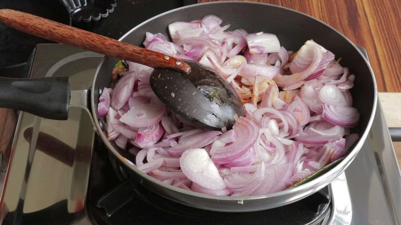 sliced onions cooking on the stove top with spices.
