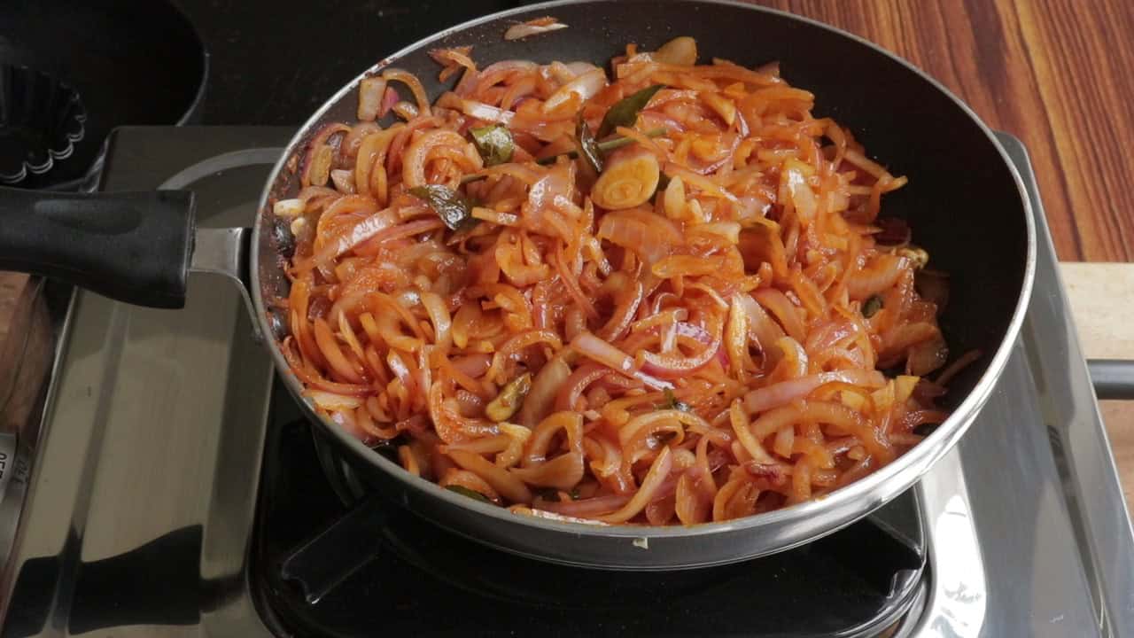 cooking the sliced onions down to make the seeni sambol.