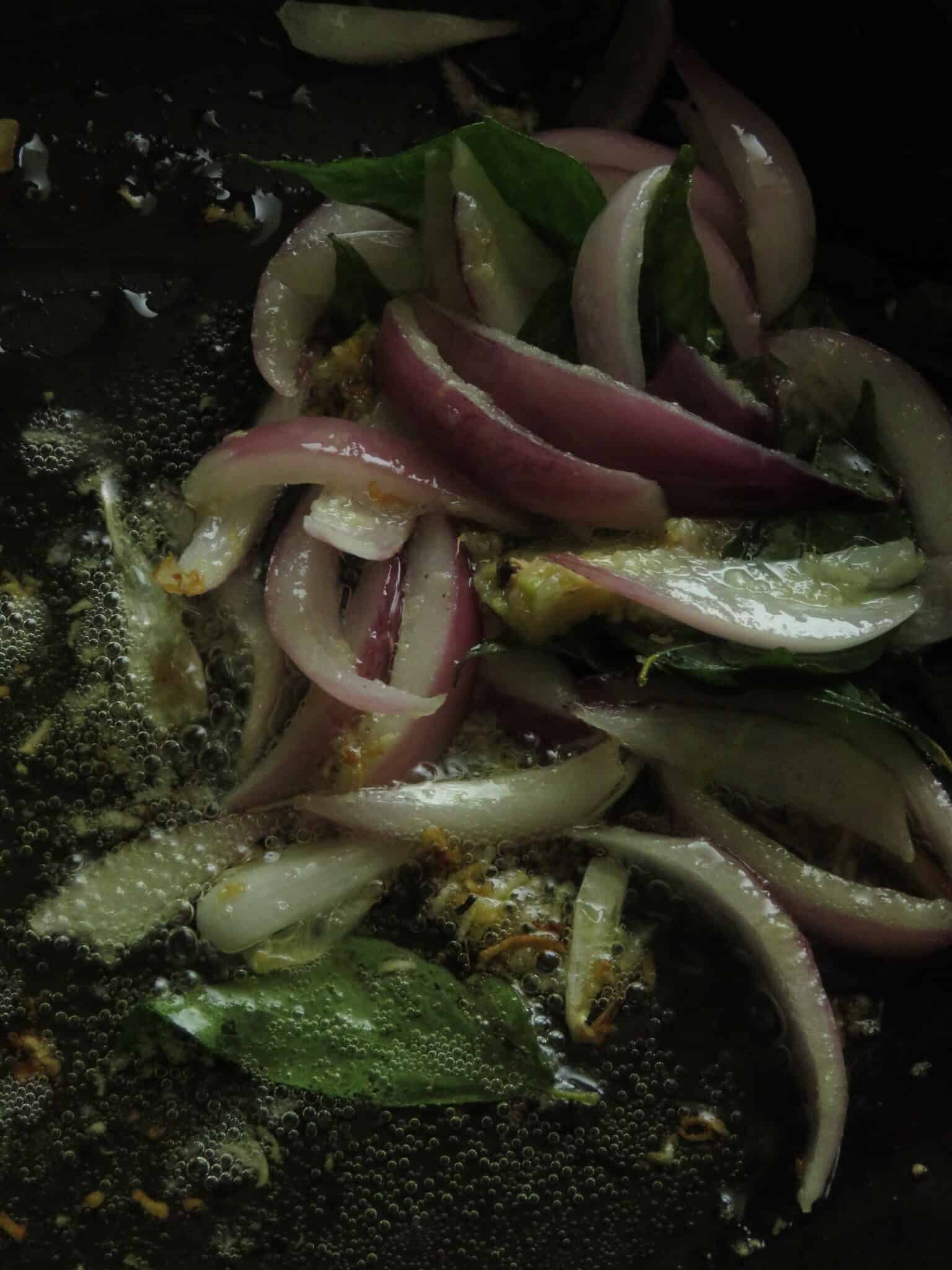 onions, garlic, ginger , curry leaves sauteing in a pan with a few table spoons of oil.