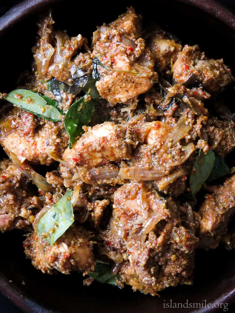 Spicy Indian chicken sukka in a pan with onions and curry leaves.