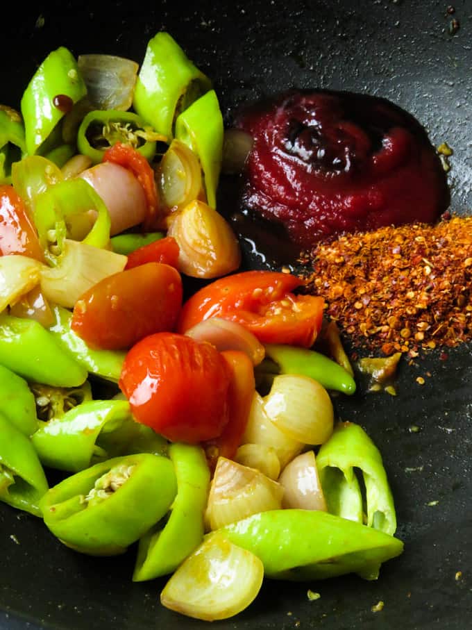 adding the sauces for the chicken chilli fry