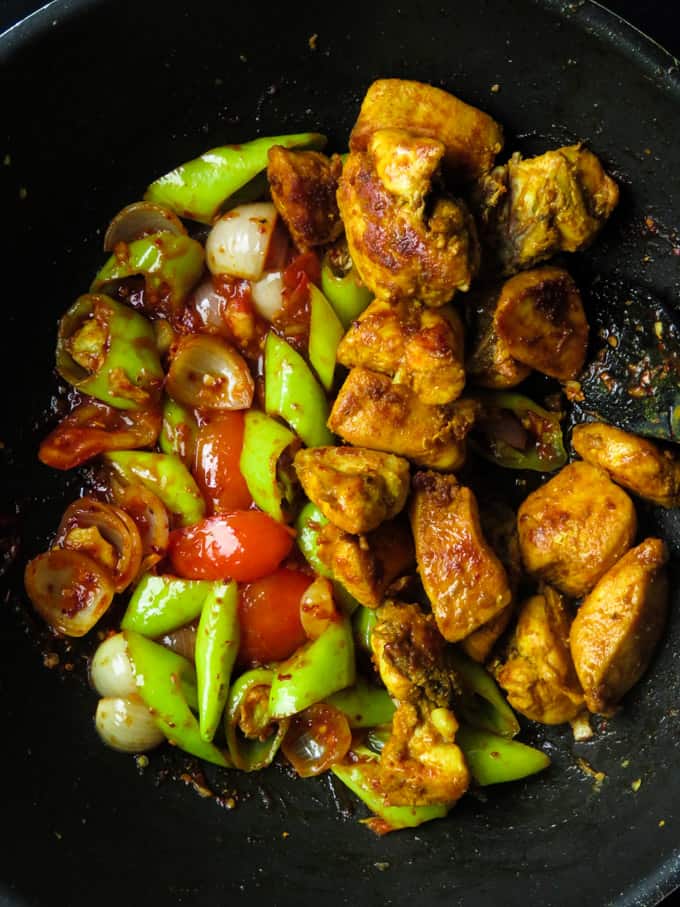 adding the fried chicken to the stir-fry.