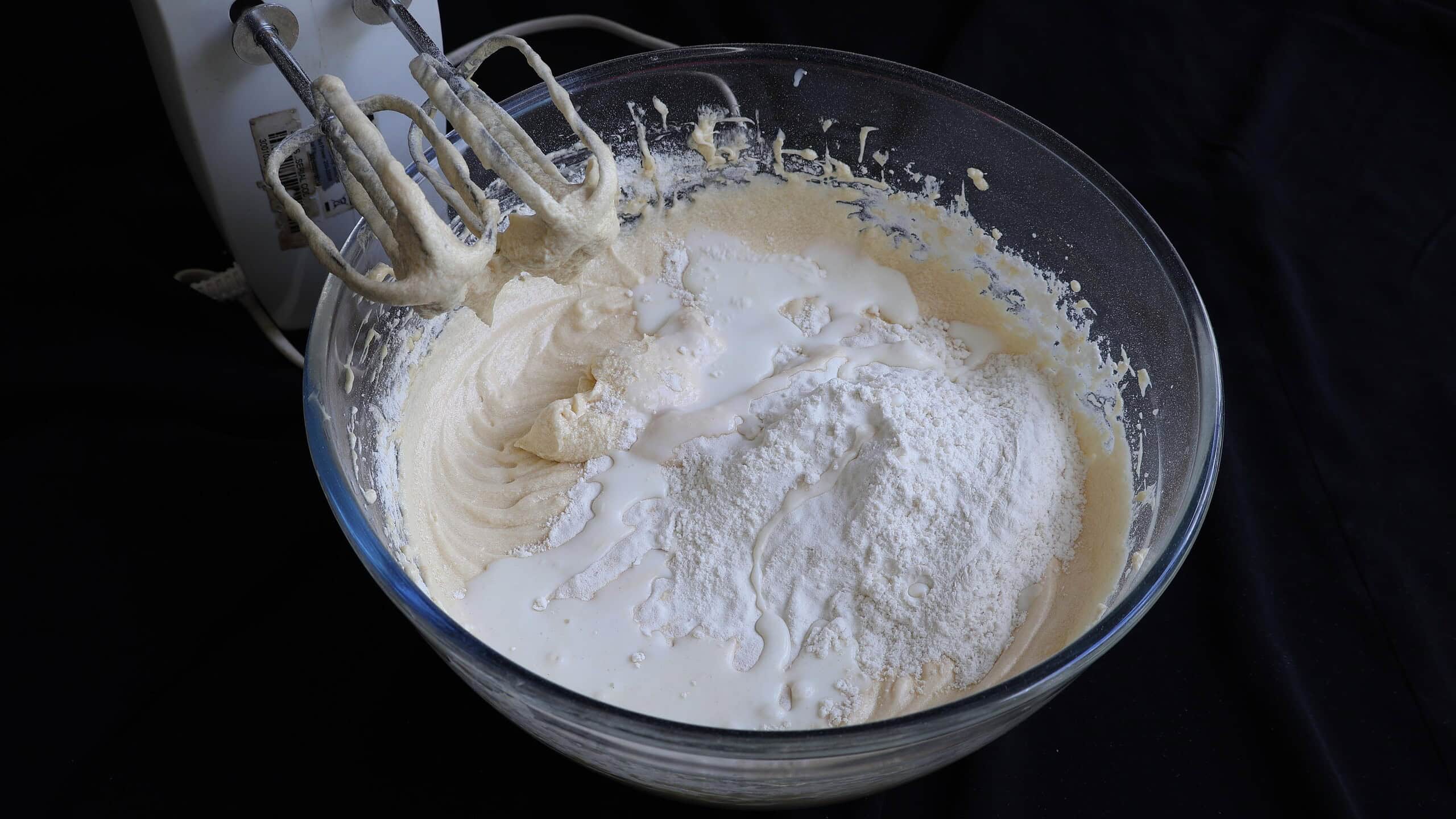 adding flour and milk to the butter cake mixture.