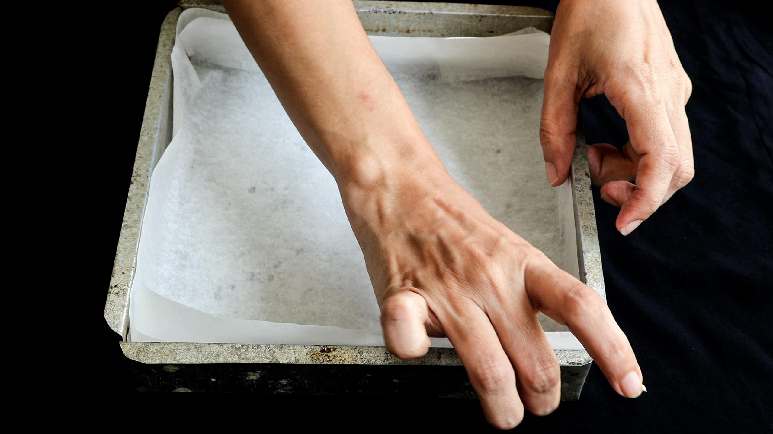 attaching the baking paper to the baking pan.