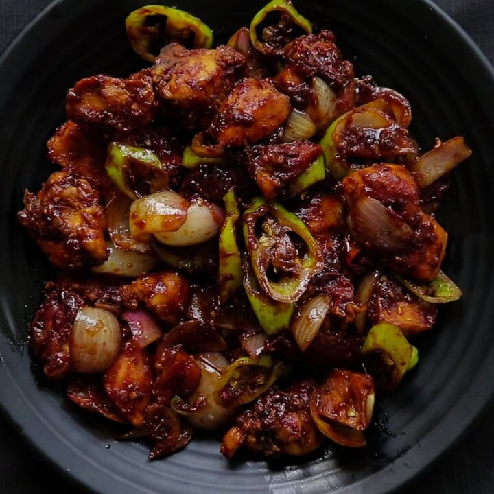 crispy devilled chicken served on a black platter.