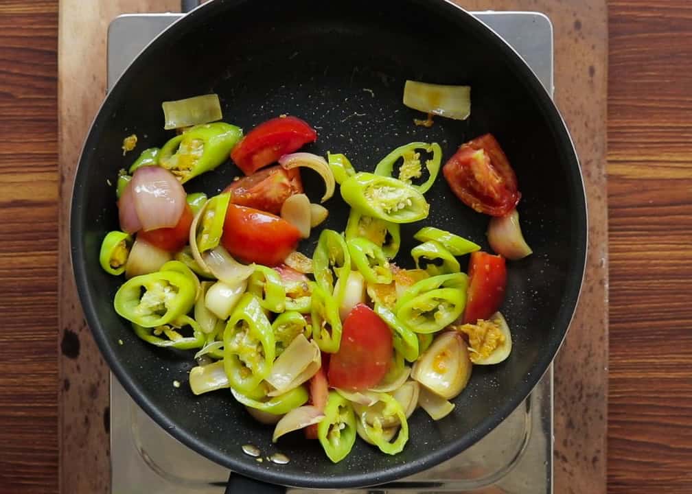 wedges of banana pepper, tomatoes and onions cooked to make the deviled chicken.