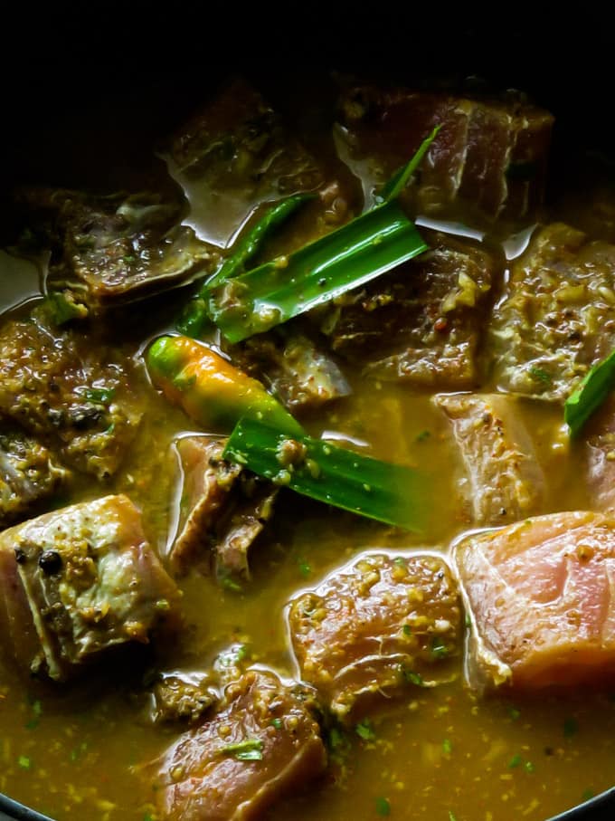 adding water to the fish curry.