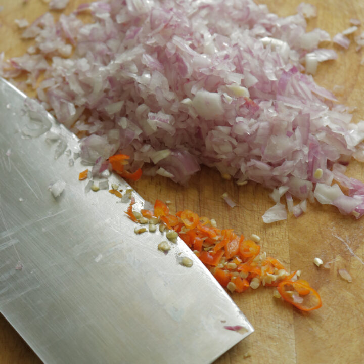 chopping onions, green chillies to make the fish cutlets.