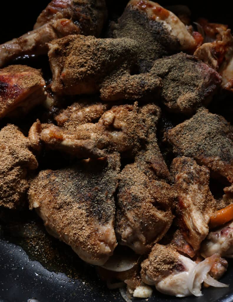 adding black pepper and spices to cook the black pepper chicken curry.