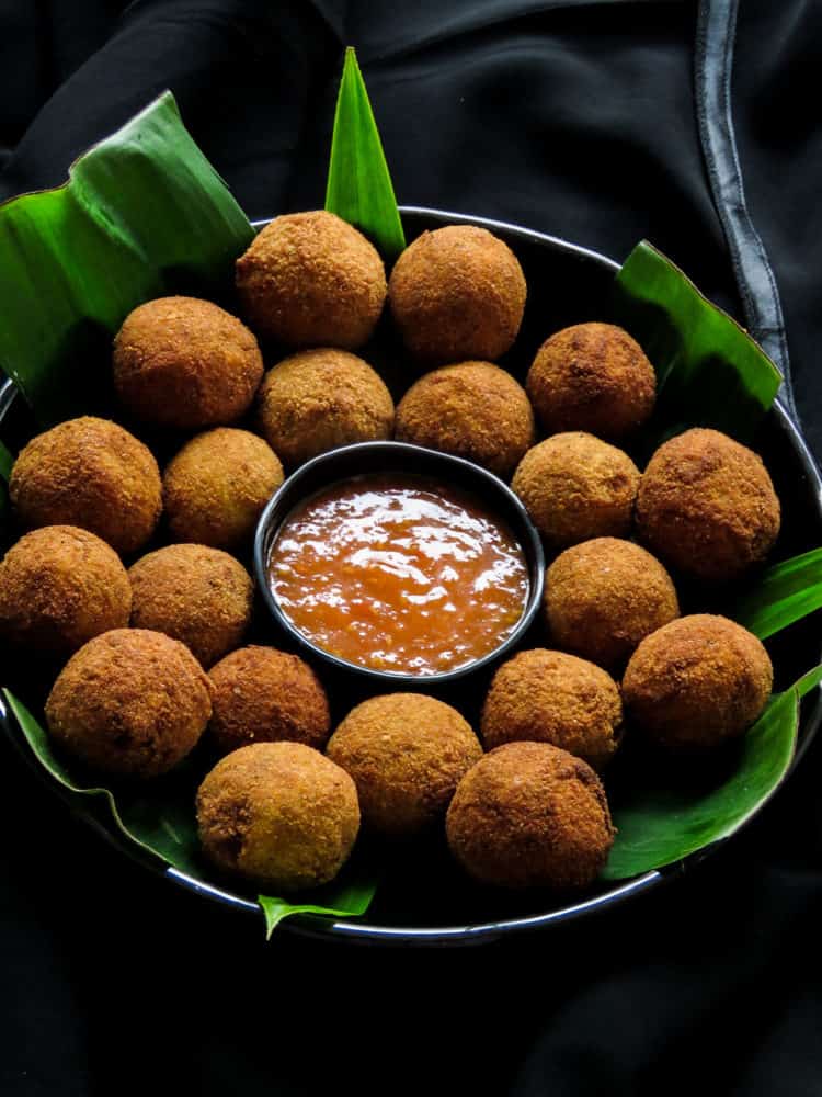 Deep-fried Sri Lankan fish cutlets, served on a plate with a sauce.