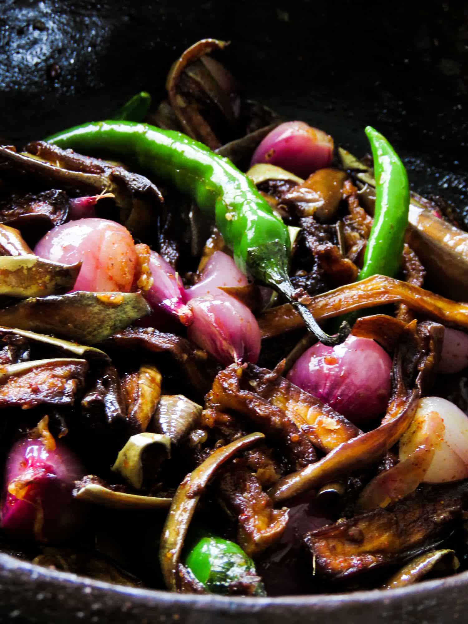 wambotu moju a fried eggplant, shallots, green chillies mixed with mustard placed in a clay pot