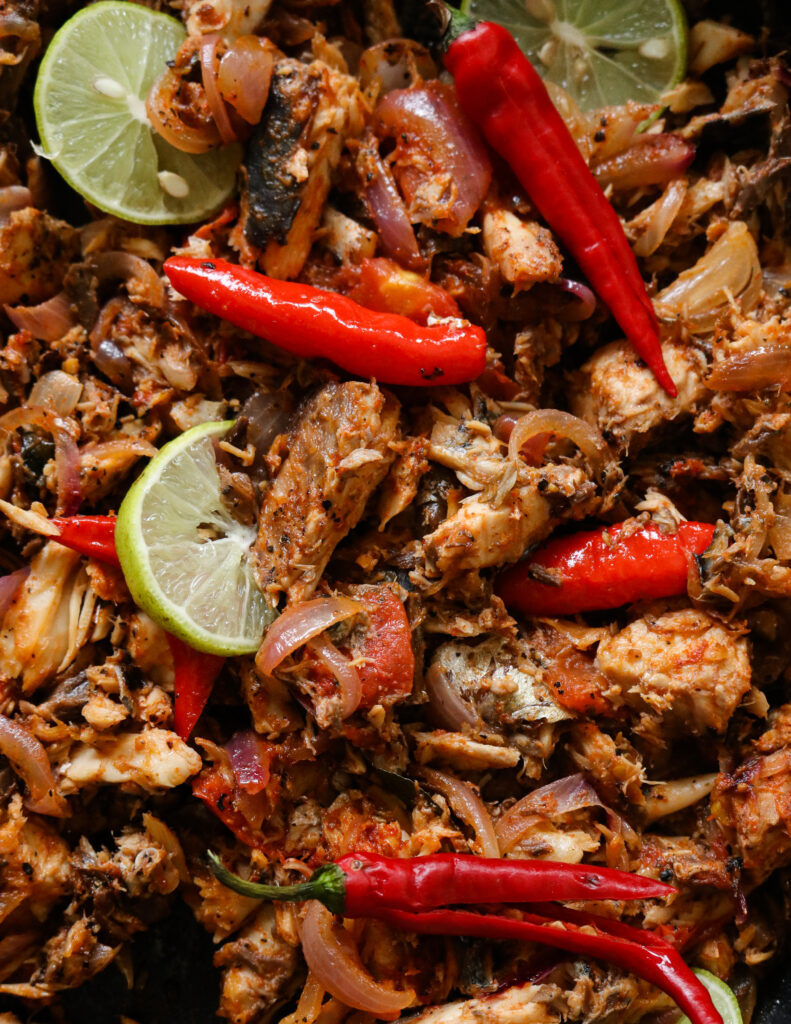 canned mackerek cooked and broken into pieces with red chillies and lime slices.