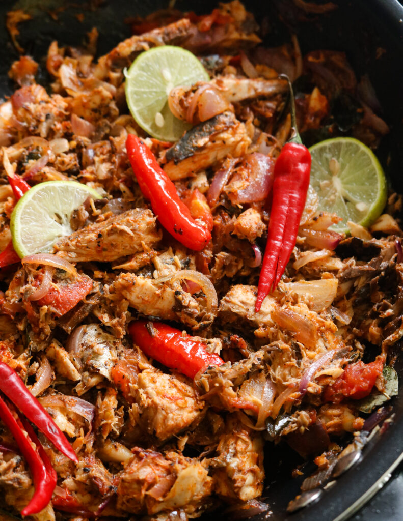 pieces of mackerel with red chillies slices of lime.