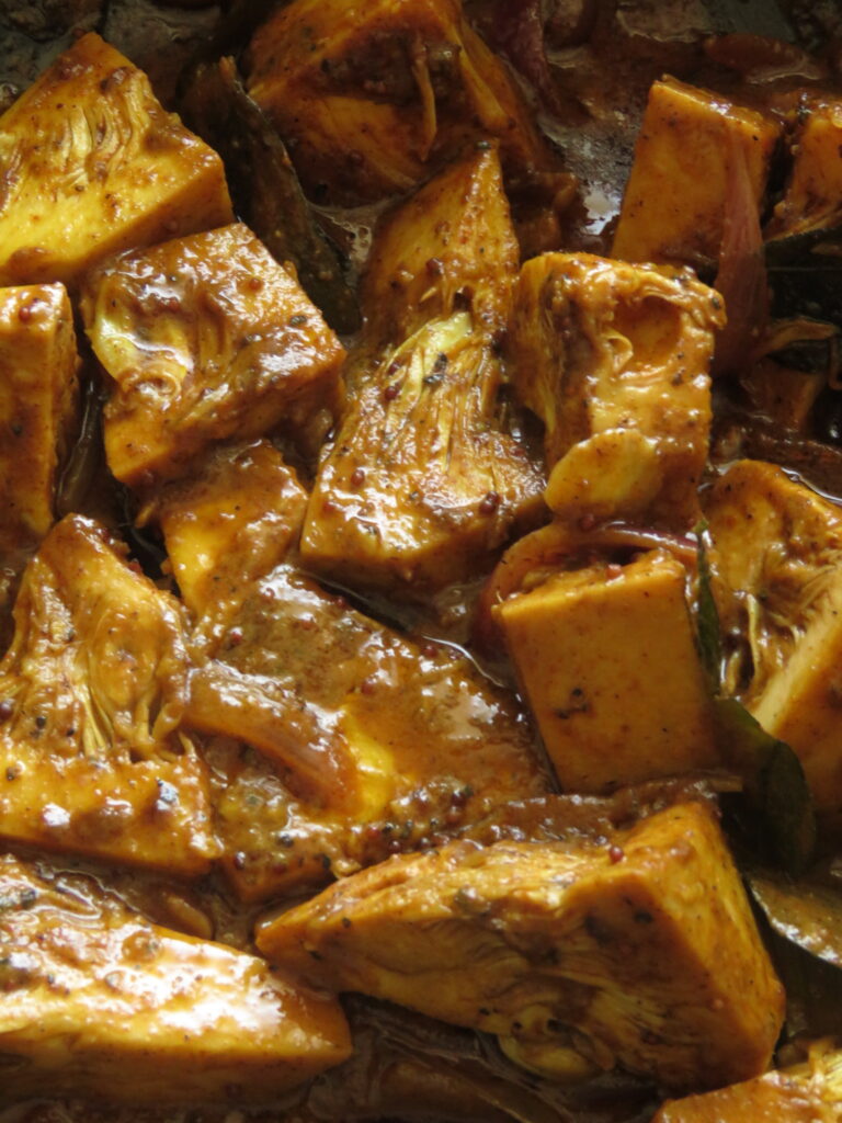 baby jackfruit cooking in mustard and curry powders.