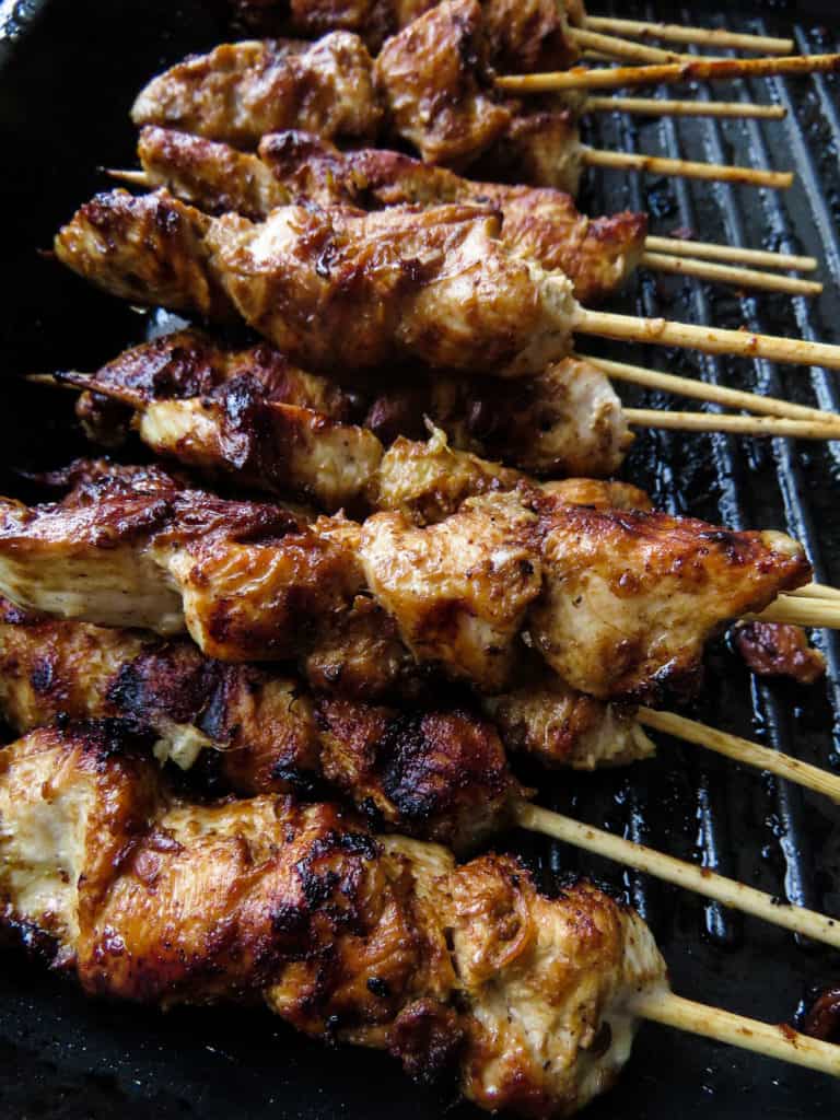 juicy tender chicken cubes in skewers/chicken satay on a grill pan.