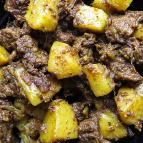 Slow cooked Indian beef and potato curry- tender meat and potatoes cooked in spices to flavor the dry gravy. this rich curry just needs a few garlic naans, roti or paratha to serve as a meal. #curry #beef #indian #meal #lunch #dinner #glutenfree #meal # potato