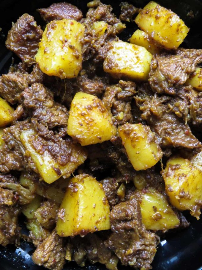 Slow cooked Indian beef and potato curry- tender meat and potatoes cooked in spices to flavor the dry gravy. this rich curry just needs a few garlic naans, roti or paratha to serve as a meal. #curry #beef #indian #meal #lunch #dinner #glutenfree #meal # potato