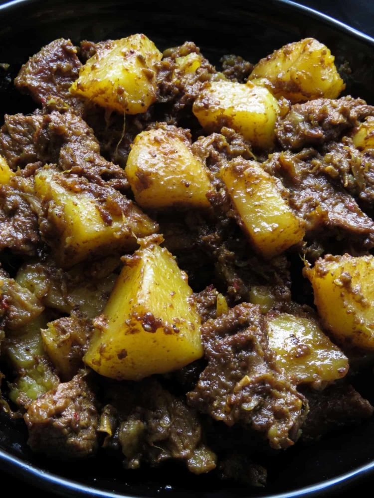 Slow cooked Indian beef and potato curry- tender meat and potatoes cooked in spices to flavor the dry gravy. this rich curry just needs a few garlic naans, roti or paratha to serve as a meal. #curry #beef #indian #meal #lunch #dinner #glutenfree #meal # potato 